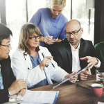 Healthcare professionals wearing medical uniforms during a team discussion
